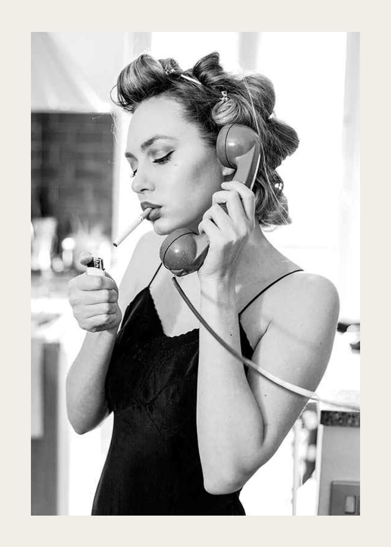 Black and white photo of woman with hair curlers, phone and cigarette-12