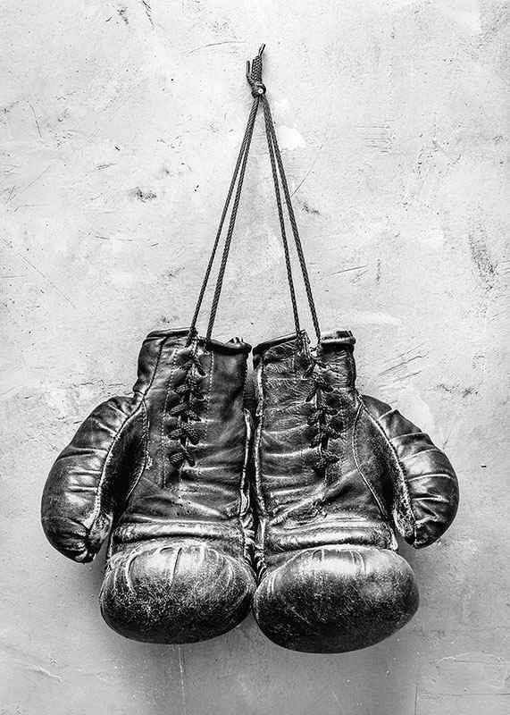 Black and white worn boxing gloves against rough wall-12