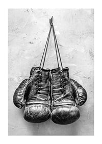 Black and white worn boxing gloves against rough wall-1