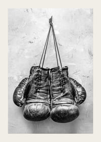Black and white worn boxing gloves against rough wall-3