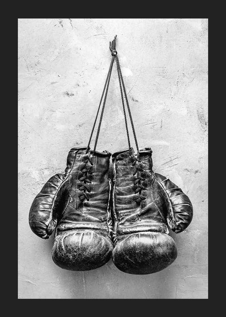 Black and white worn boxing gloves against rough wall-12