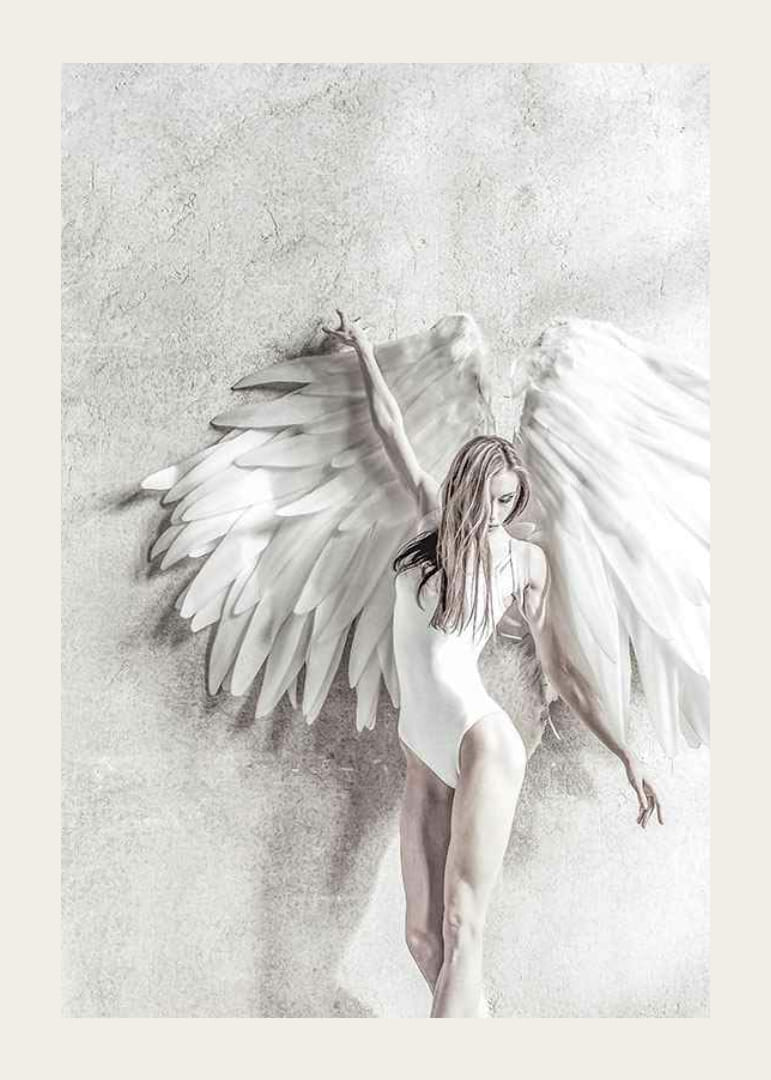 Photographie d'une femme en blanc avec de grandes ailes d'ange contre un mur clair-12