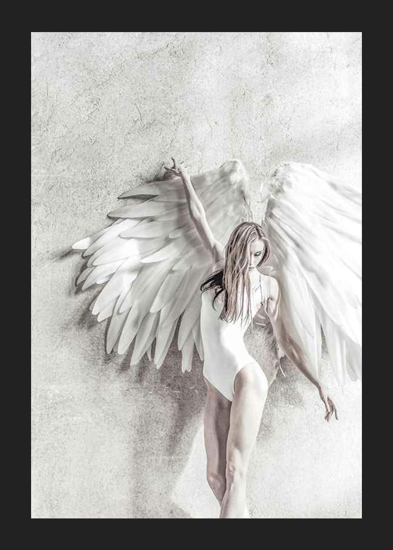 Photographie d'une femme en blanc avec de grandes ailes d'ange contre un mur clair-12