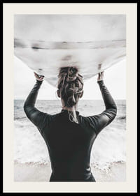 Foto van een surfer van achteren met een board boven zijn hoofd in de oceaan-2