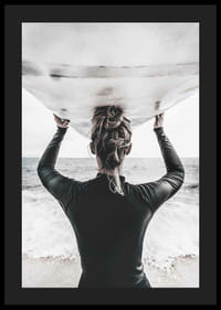 Foto van een surfer van achteren met een board boven zijn hoofd in de oceaan-4