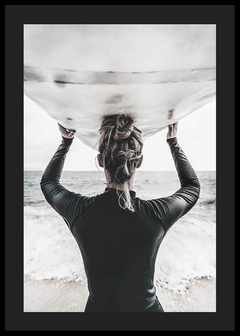 Foto van een surfer van achteren met een board boven zijn hoofd in de oceaan-12