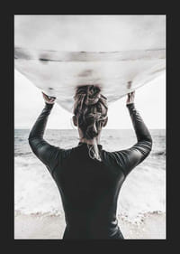 Foto van een surfer van achteren met een board boven zijn hoofd in de oceaan-5