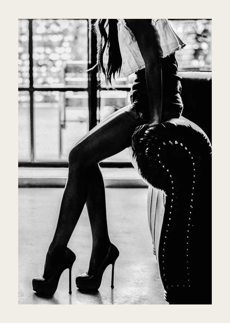 Čiernobiela módna fotografia ženy na vysokých podpätkoch pri kresle-12