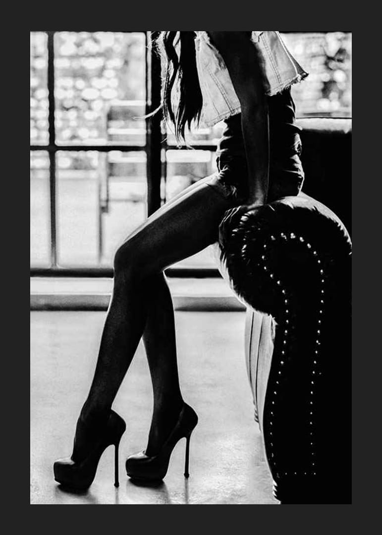 Čiernobiela módna fotografia ženy na vysokých podpätkoch pri kresle-12