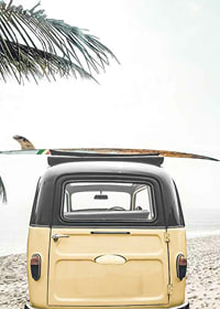 Yellow retro bus with surfboard on the roof at sandy beach-7