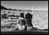Black and white photograph of two girls on car hood in front of open nature-6