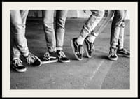 Čiernobiely detailný záber štyroch mladých ľudí v džínsoch a teniskách-2