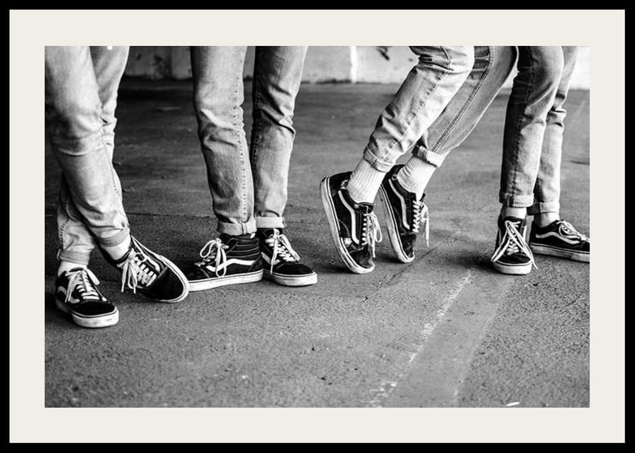 Čiernobiely detailný záber štyroch mladých ľudí v džínsoch a teniskách-12