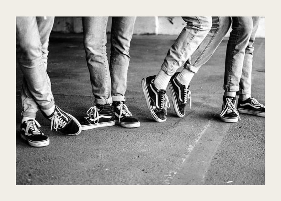 Čiernobiely detailný záber štyroch mladých ľudí v džínsoch a teniskách-12