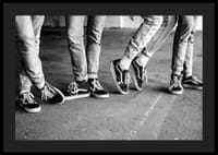 Čiernobiely detailný záber štyroch mladých ľudí v džínsoch a teniskách-4