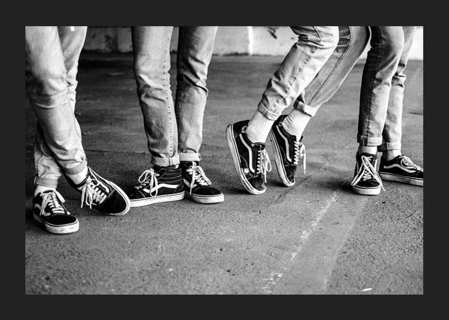 Čiernobiely detailný záber štyroch mladých ľudí v džínsoch a teniskách-12