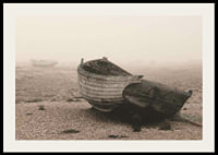 Photograph of old wooden boat on rocky beach in fog-2