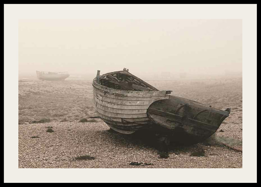 Photograph of old wooden boat on rocky beach in fog-12