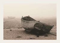 Photograph of old wooden boat on rocky beach in fog-3