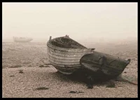Photograph of old wooden boat on rocky beach in fog-6