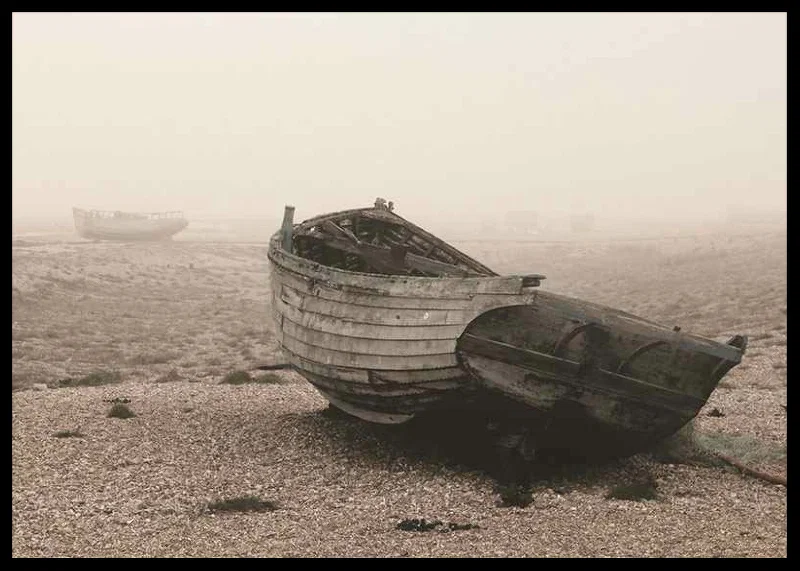 Photograph of old wooden boat on rocky beach in fog-12