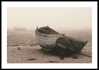 Photograph of old wooden boat on rocky beach in fog-0