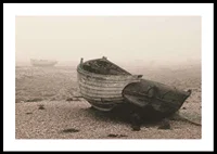 Photograph of old wooden boat on rocky beach in fog-0