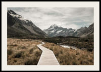 Fotografi av spång genom dal med snötäckta berg i bakgrunden-2
