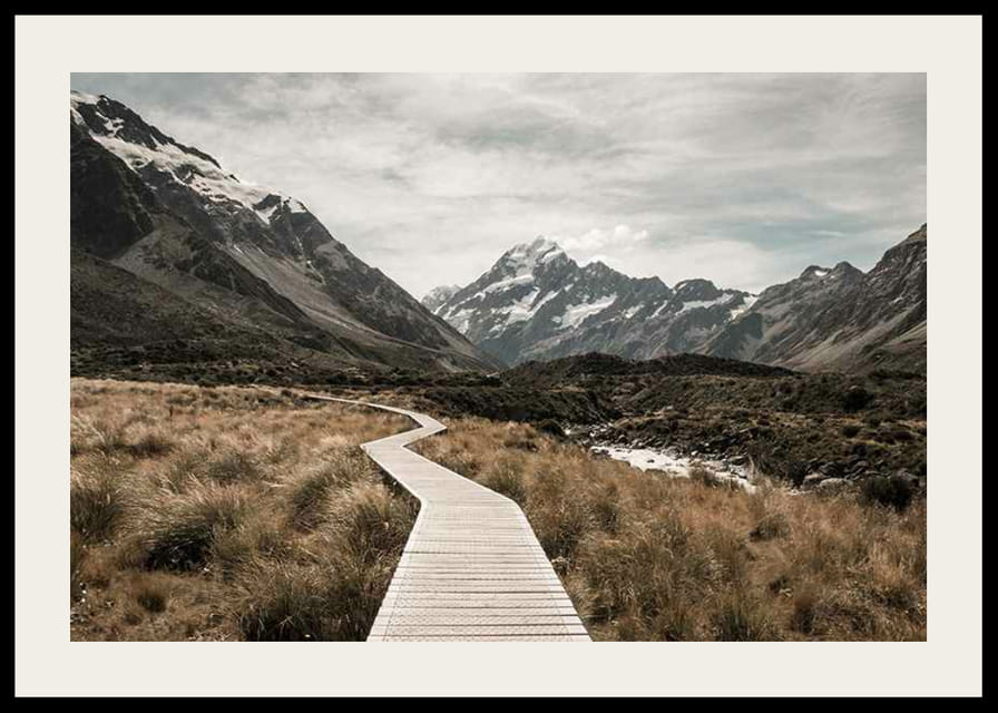 Fotografi av spång genom dal med snötäckta berg i bakgrunden-12
