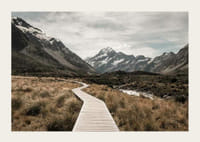 Fotografi av spång genom dal med snötäckta berg i bakgrunden-3