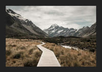 Fotografi av spång genom dal med snötäckta berg i bakgrunden-5