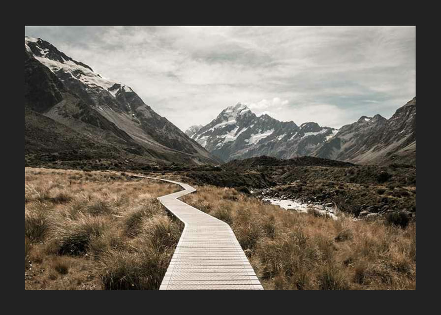 Fotografi av spång genom dal med snötäckta berg i bakgrunden-12