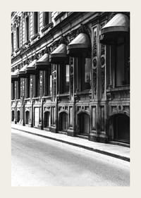 Fachada en blanco y negro de una calle de la ciudad antigua con ventanas decoradas-3