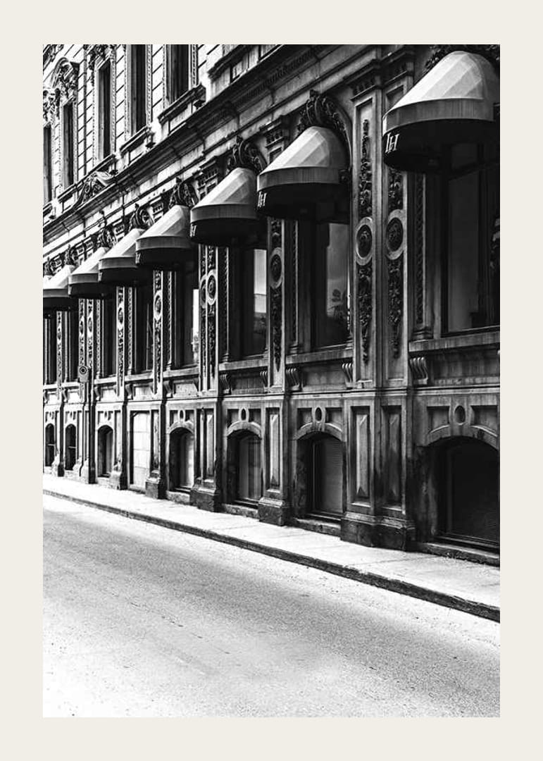 Fachada en blanco y negro de una calle de la ciudad antigua con ventanas decoradas-12