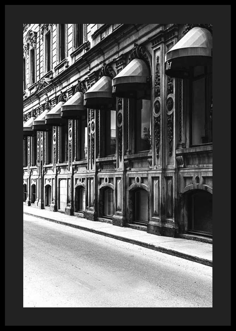 Fachada en blanco y negro de una calle de la ciudad antigua con ventanas decoradas-12