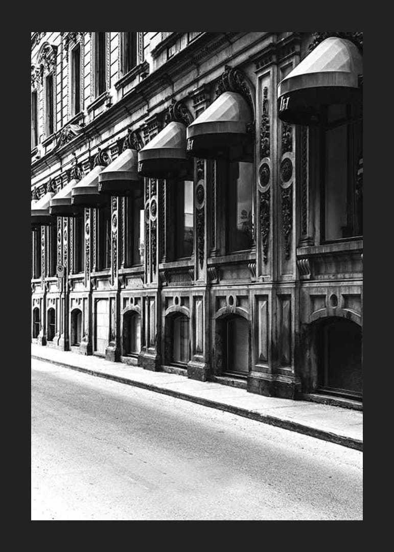 Fachada en blanco y negro de una calle de la ciudad antigua con ventanas decoradas-12