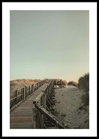 Photograph of wooden pier over sand dunes against bright sky-0