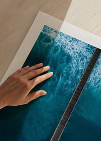 Fotografisk vy rakt ovanifrån av lång brygga i blått hav-9