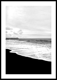 Black and white photograph of waves against dark beach and horizon-0
