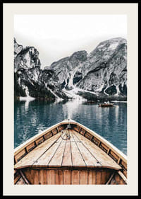 Fotografie eines Holzbootes auf türkisfarbenem Wasser vor schneebedeckten Bergen-2