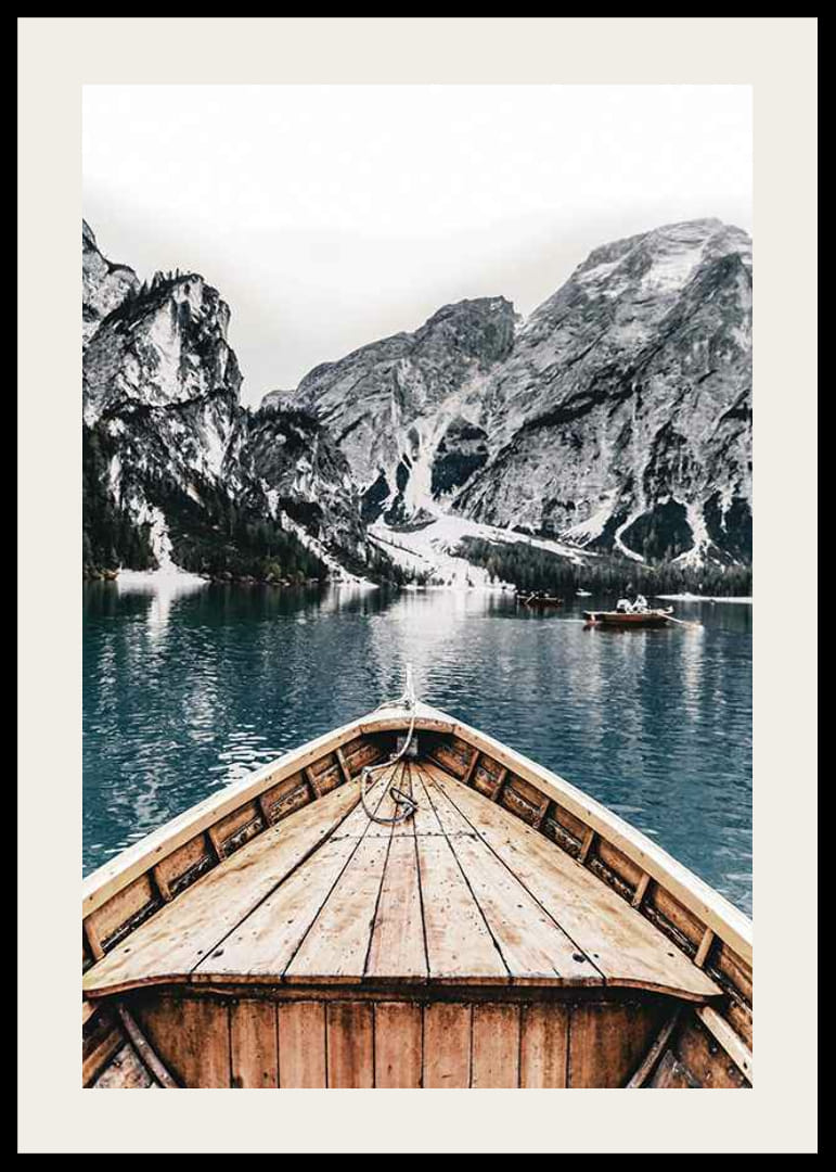 Fotografie eines Holzbootes auf türkisfarbenem Wasser vor schneebedeckten Bergen-12