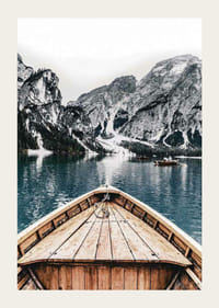 Fotografie eines Holzbootes auf türkisfarbenem Wasser vor schneebedeckten Bergen-3