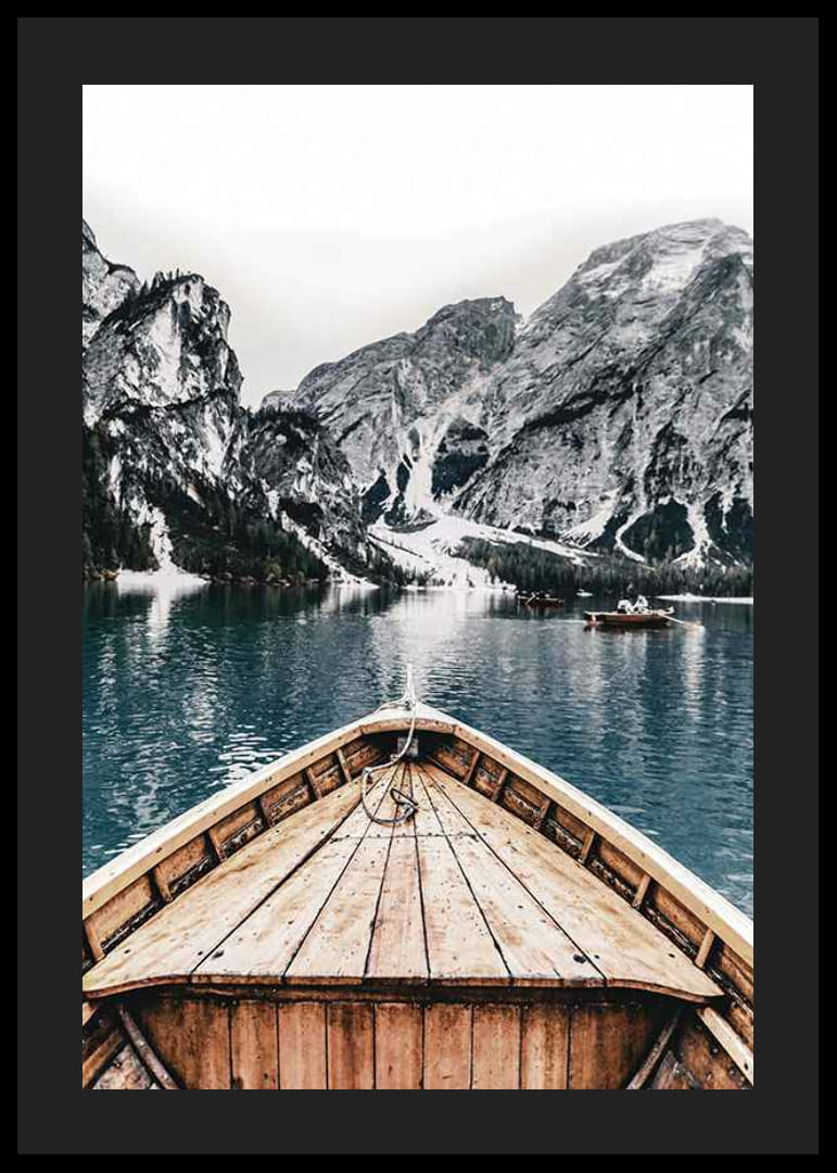 Fotografie eines Holzbootes auf türkisfarbenem Wasser vor schneebedeckten Bergen-12