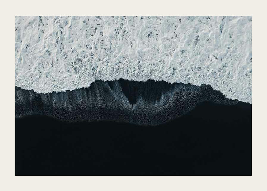 Widok z lotu ptaka na białe fale na tle czarnej lawy na plaży-12