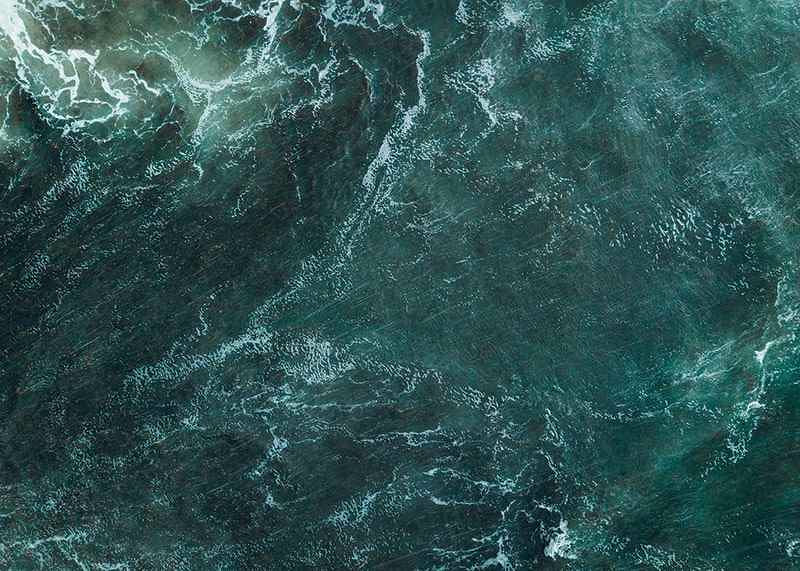 Aerial view of turquoise sea with white wave patterns and foam-12