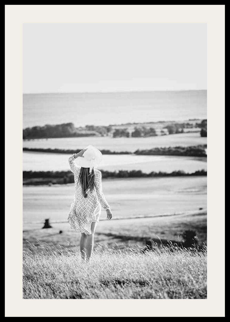 Black and white photograph of woman in dress in Danish countryside-12