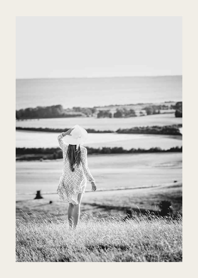 Black and white photograph of woman in dress in Danish countryside-12