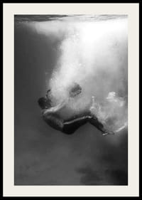 Zwart-witfoto van een man die onder het wateroppervlak zinkt-2