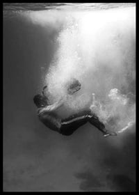 Black and white photograph of man sinking below water surface-6