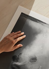 Black and white photograph of man sinking below water surface-9